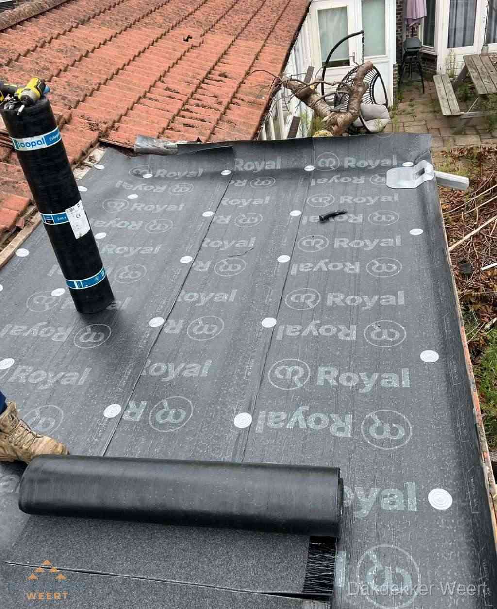 Plat dak met nieuwe bitumen dakbedekking en brandgereedschap in Weert