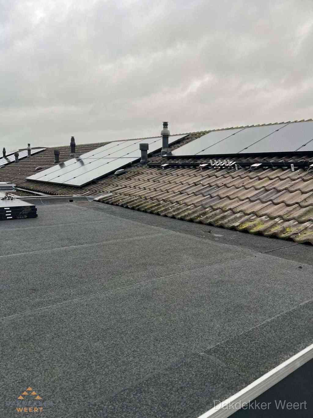 Plat dak inspectie met bitumen bedekking naast schuin pannendak in Weert