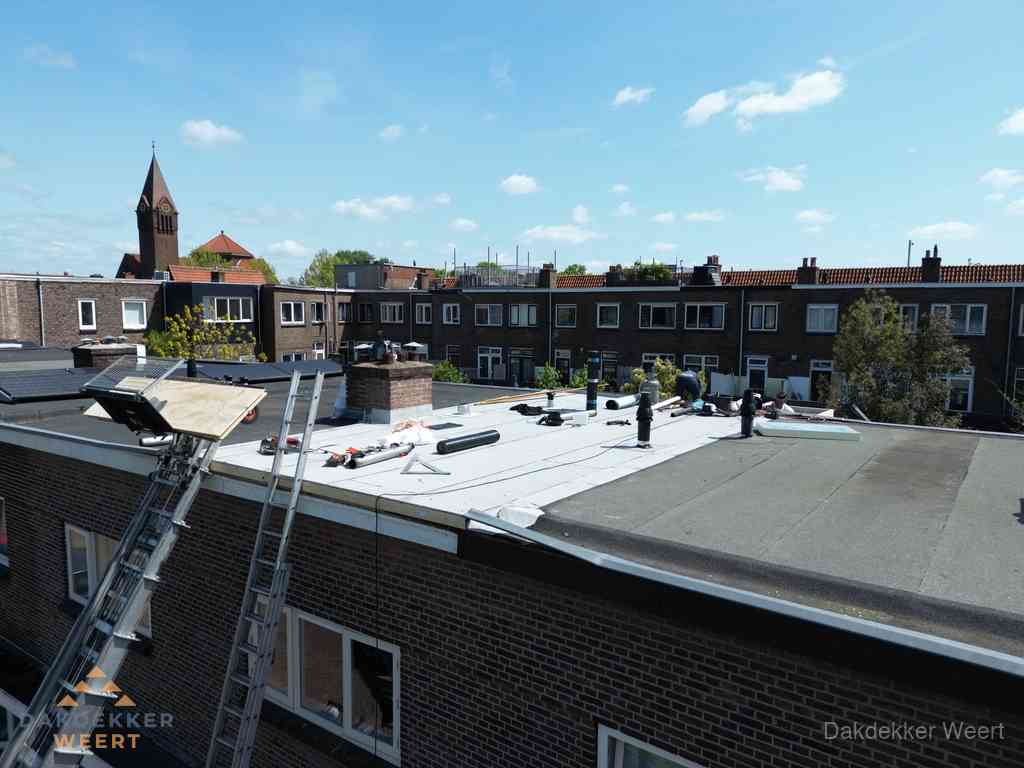 Dakdekkers aan het werk op plat dak in Weert