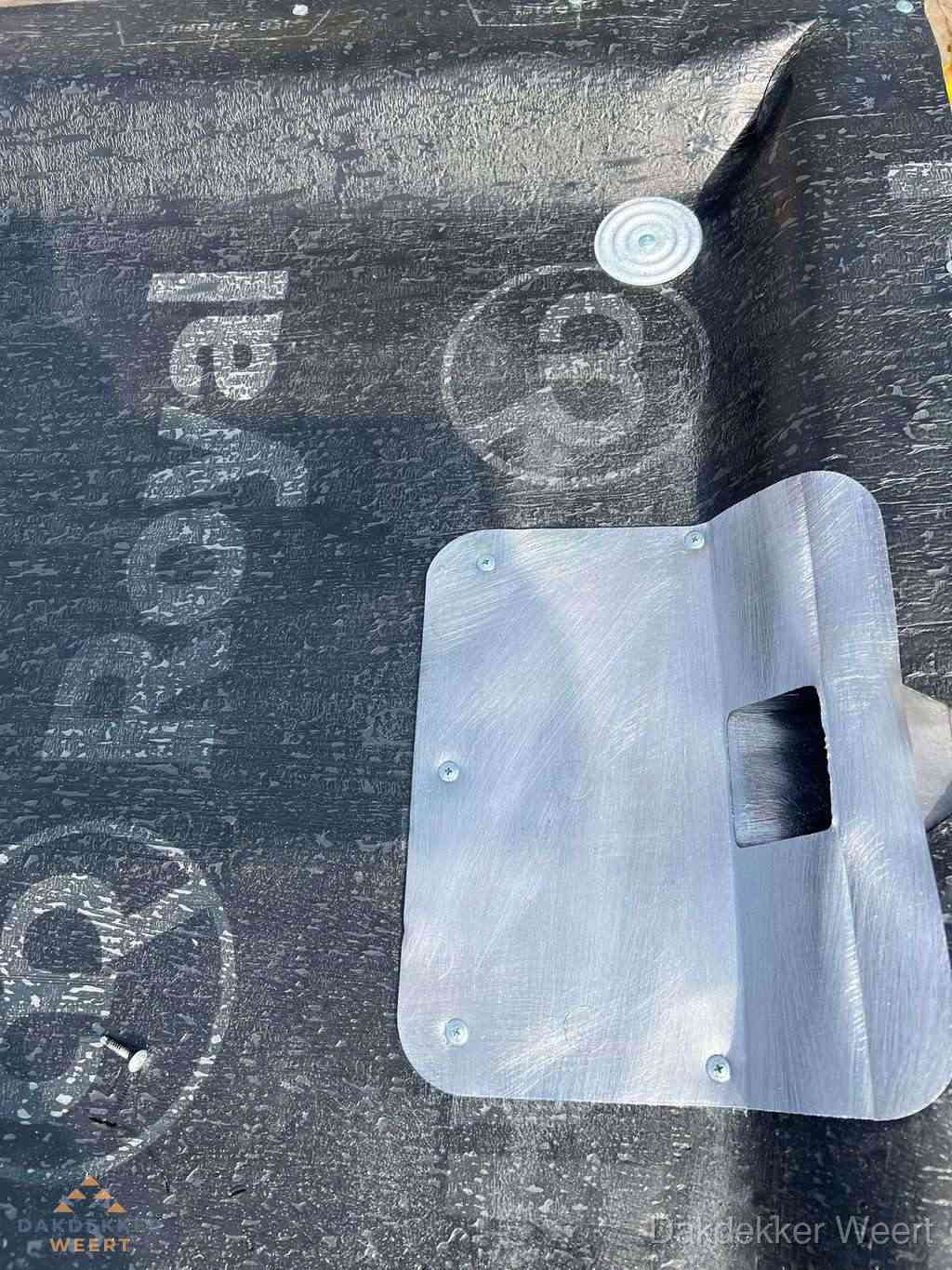 Dakdoorvoer met metalen afvoerplaat op bitumen dak in Weert