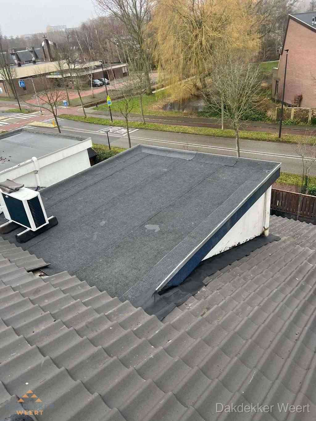Plat dak met bitumen dakbedekking naast schuin pannendak in Weert