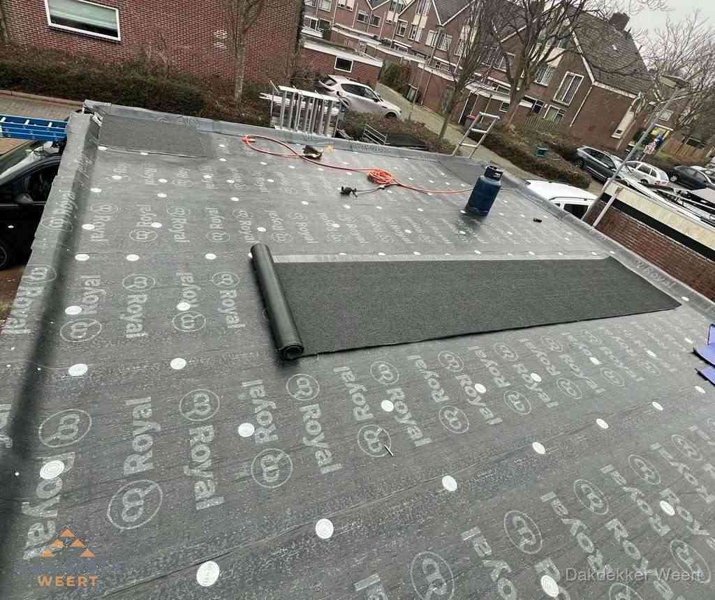 Dakdekker aan het werk met gasbrander op plat bitumen dak in Weert